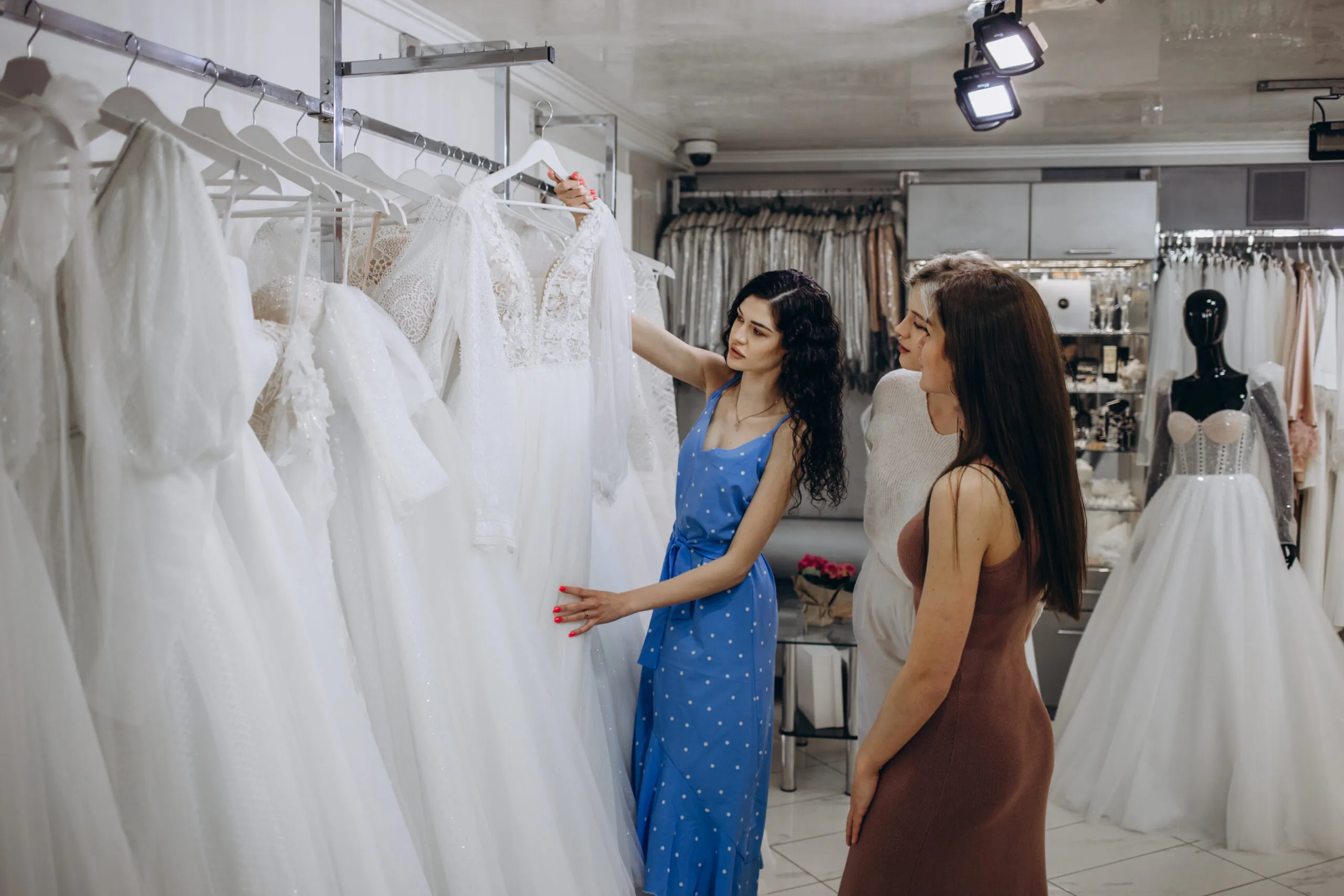 Vittrine Locação de Trajes - bride with friends choosing wedding dress boutique scaled 1